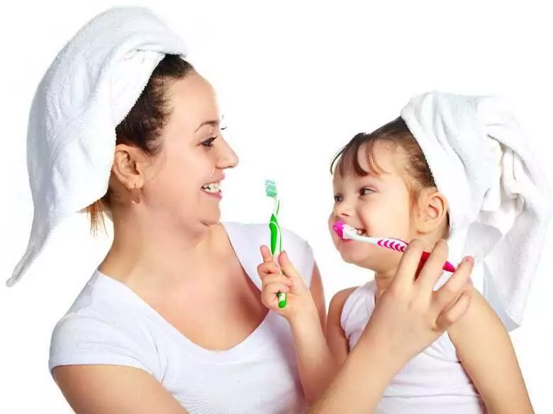 How do I brush my child's first teeth?